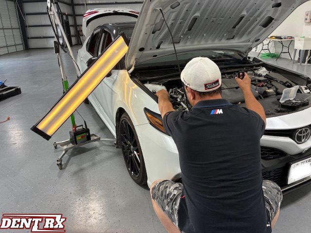 Mechanic repairing car in garage workshop.